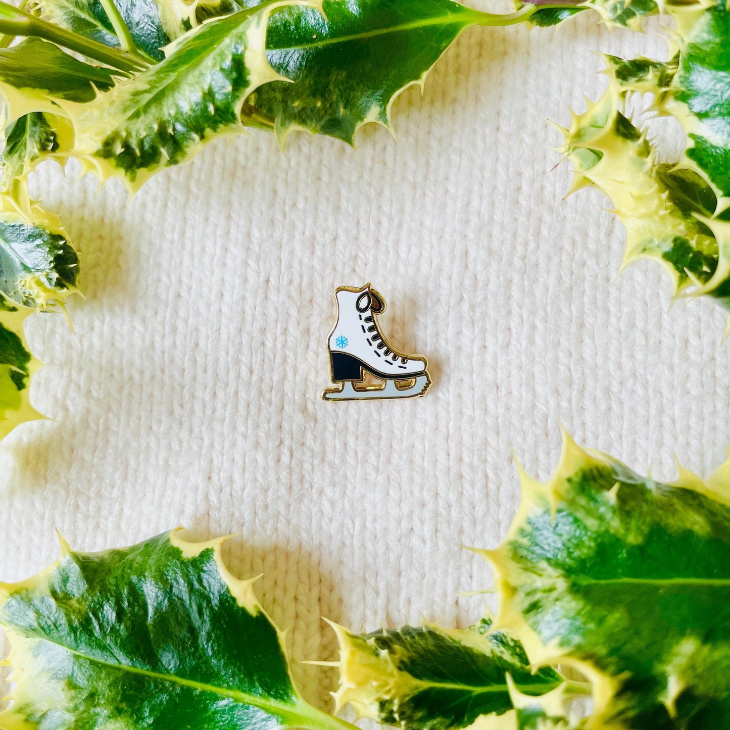 White and black ice skate with blue snowflake detail gold hard enamel mini pin