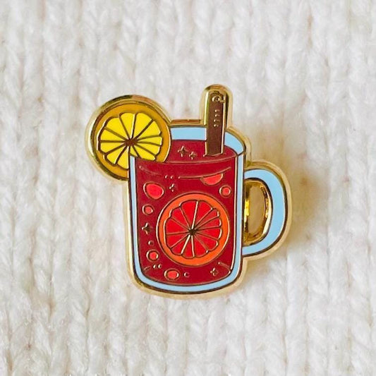 Red mulled wine mulled apple cider gluhwein in glass with orange and cinnamon gold hard enamel mini pin badge
