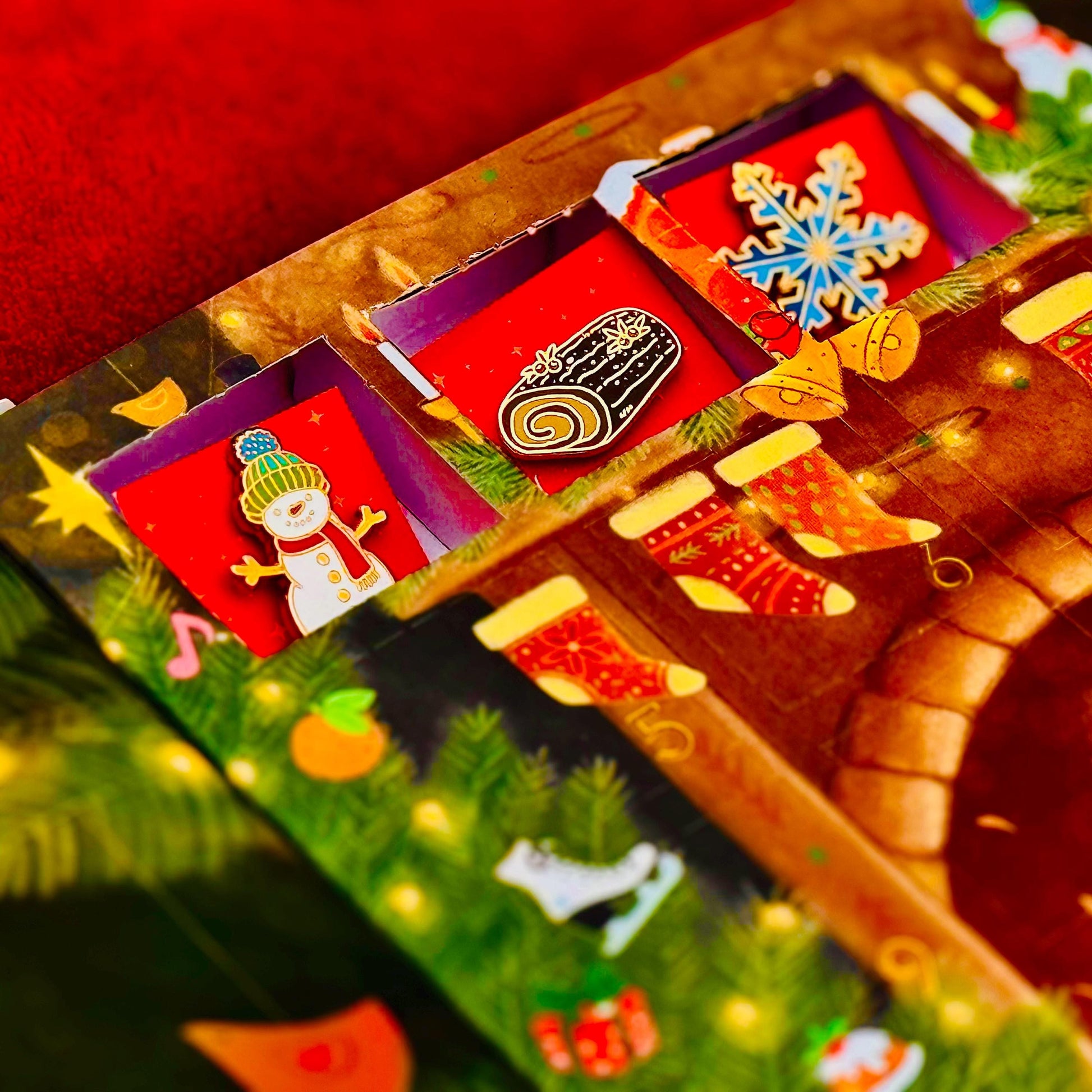 The image is a colorful and festive Christmas-themed advent calendar, featuring various holiday decorations such as a snowman, stockings, and a log.