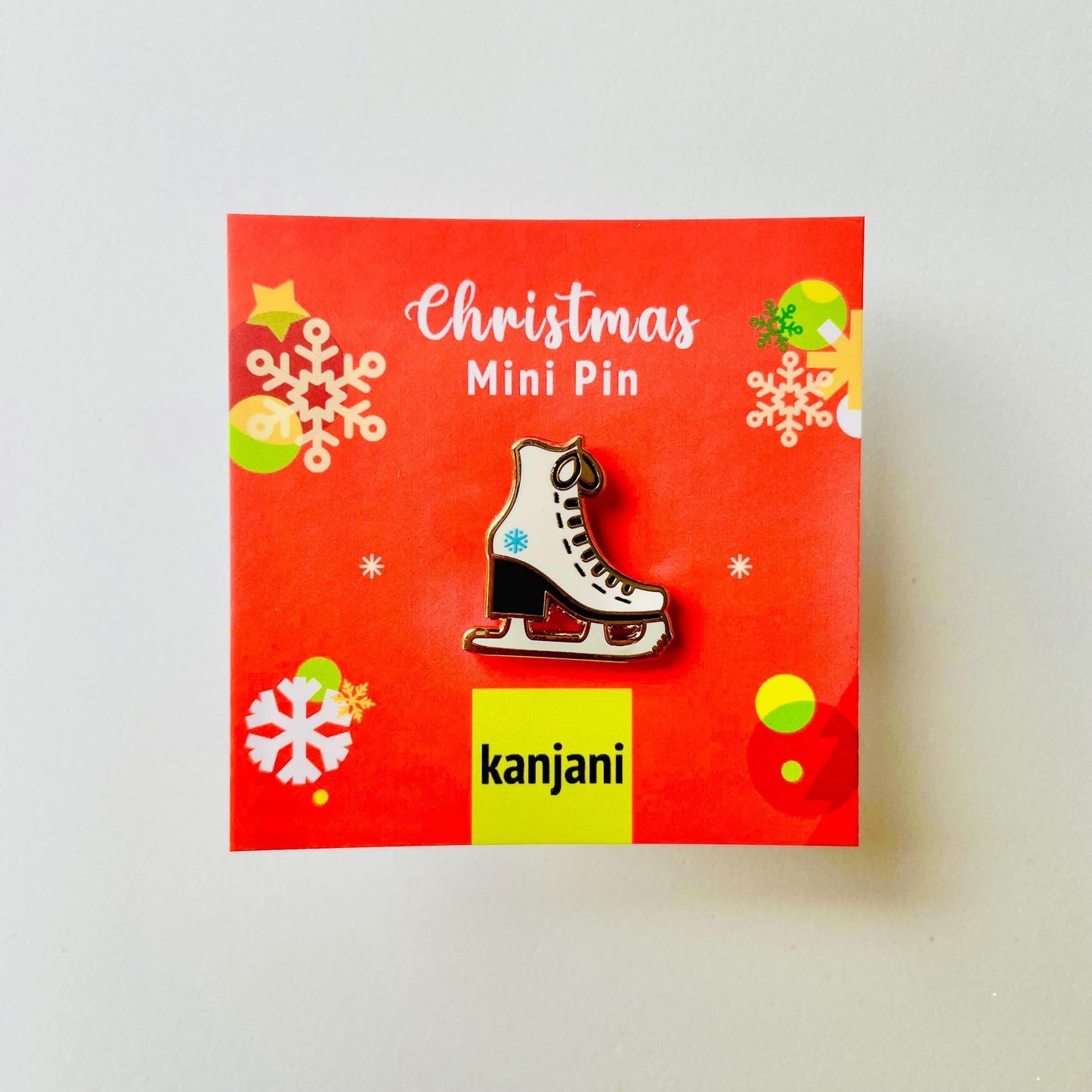 White and black ice skate with blue snowflake detail gold hard enamel mini pin