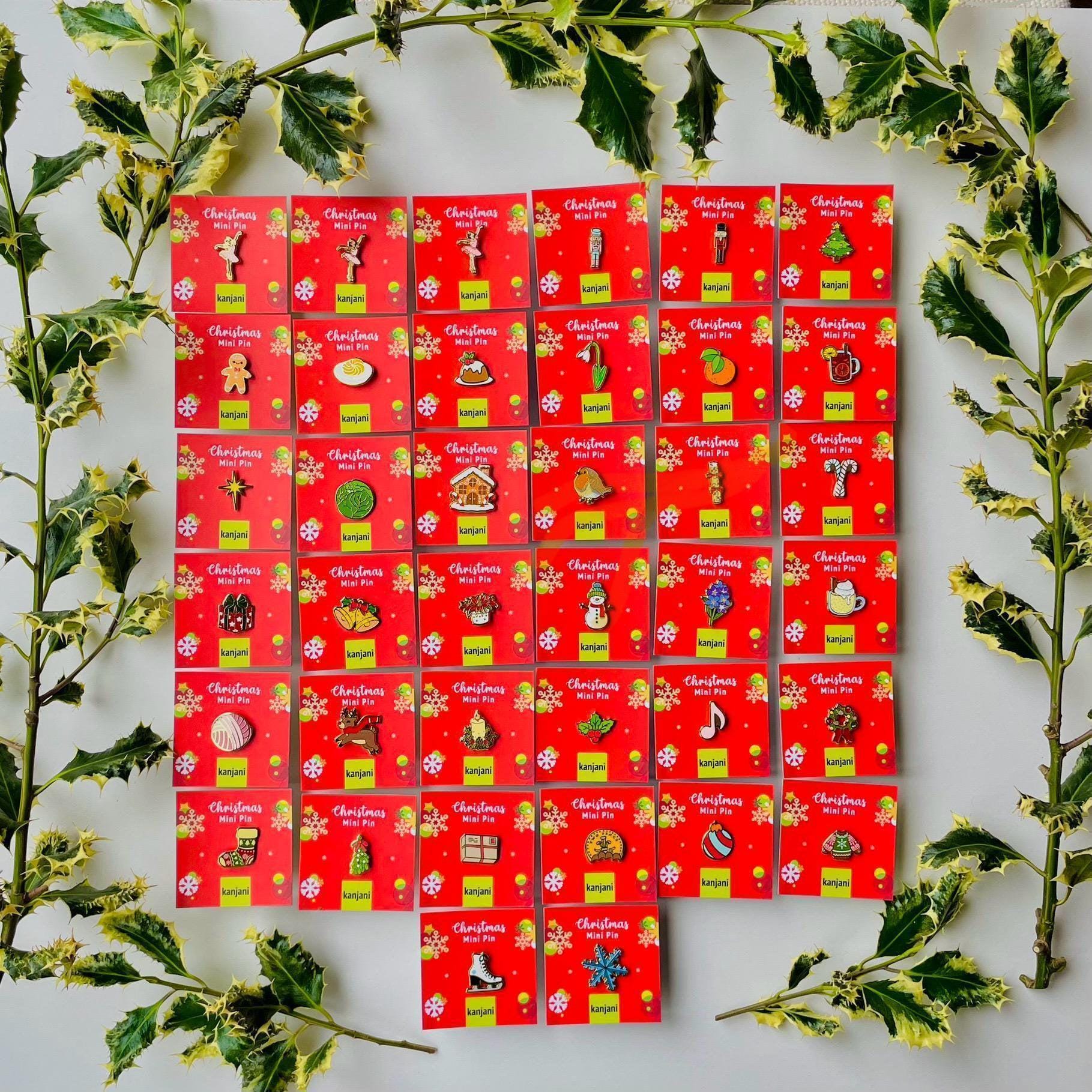 a collection of Christmas-themed pins arranged in a grid pattern on a white background. The pins are red and yellow, and each one has a unique design or symbol associated with the Christmas holiday season. The pins are surrounded by green leaves, creating a festive and holiday atmosphere.