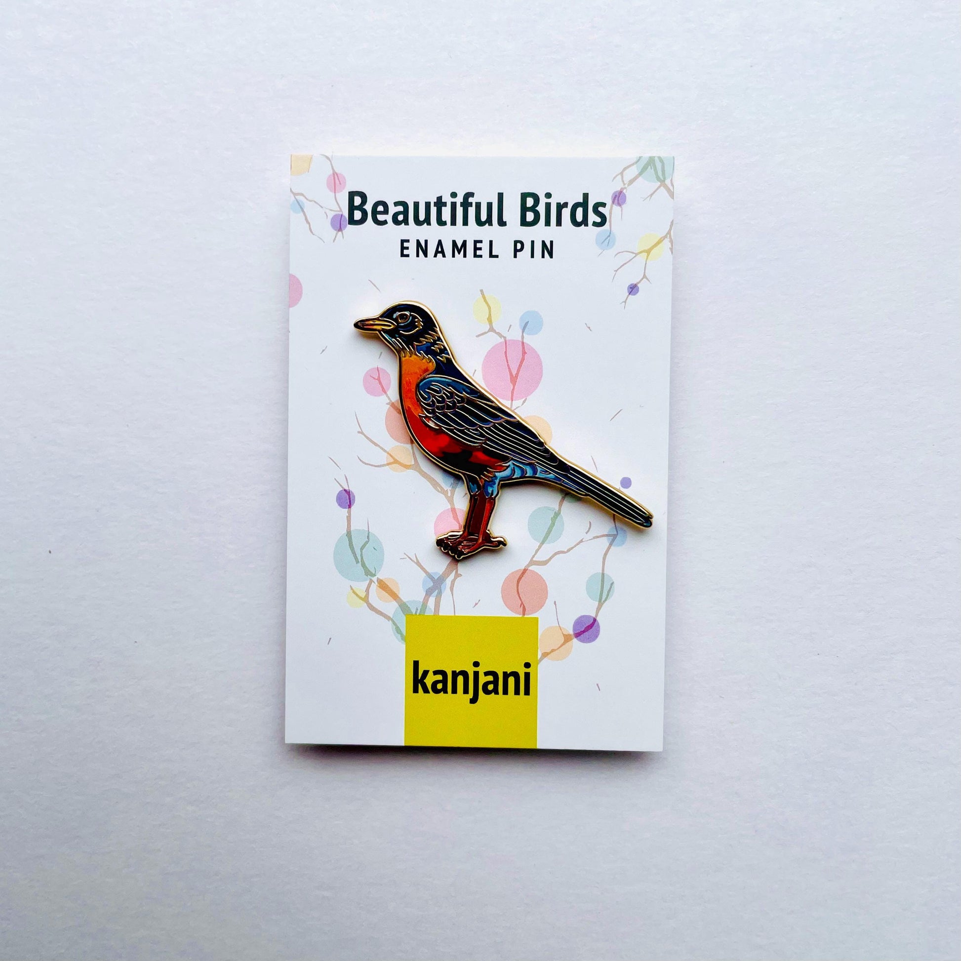 a colorful pin of a bird, which is described as a beautiful bird enamel pin.