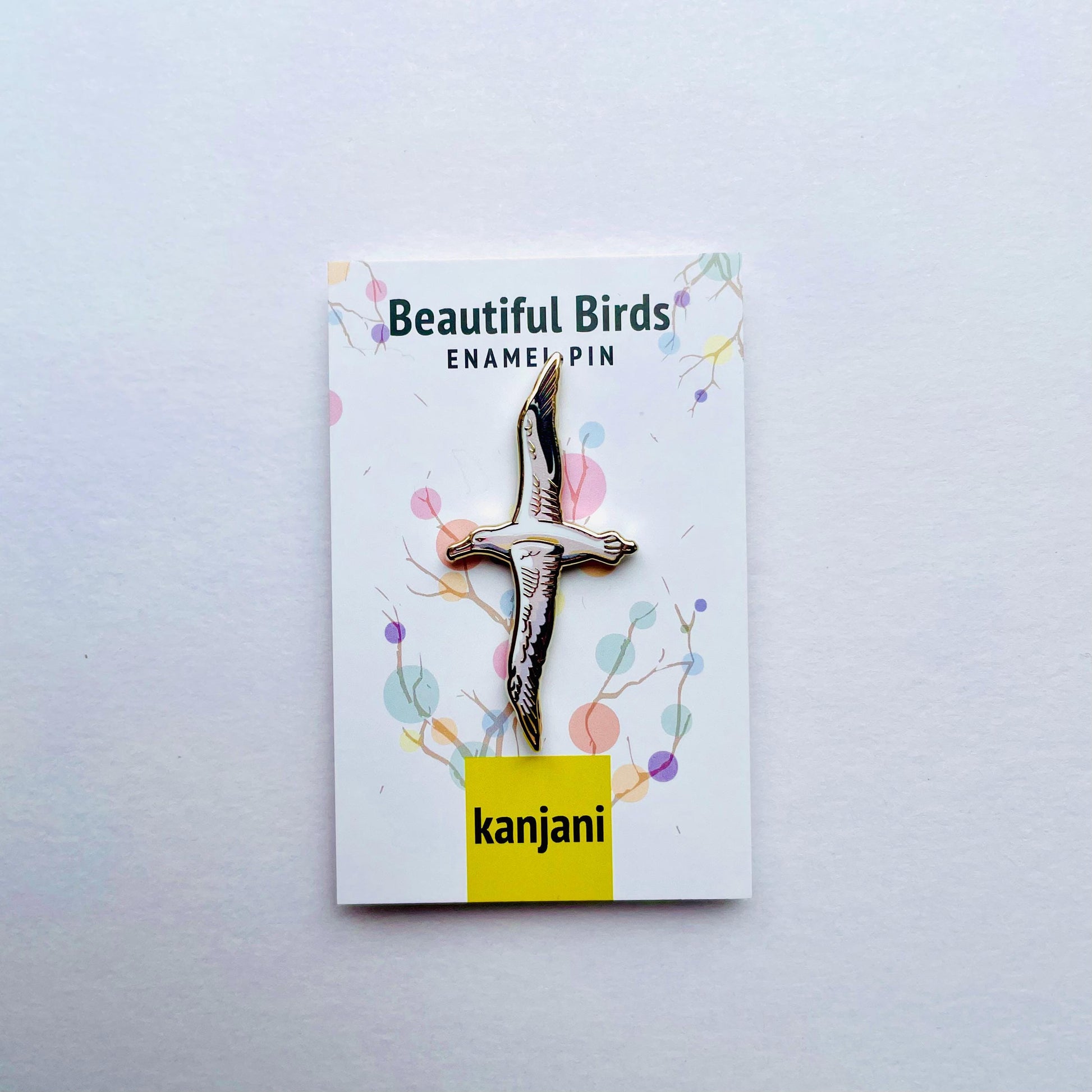 a pin with a bird design, placed on a white background.